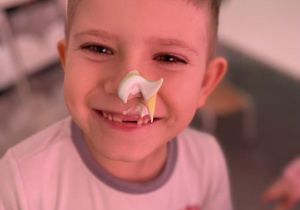 uśmiechnięty chłopiec z kleksem z kolorowej pianki na nosie
